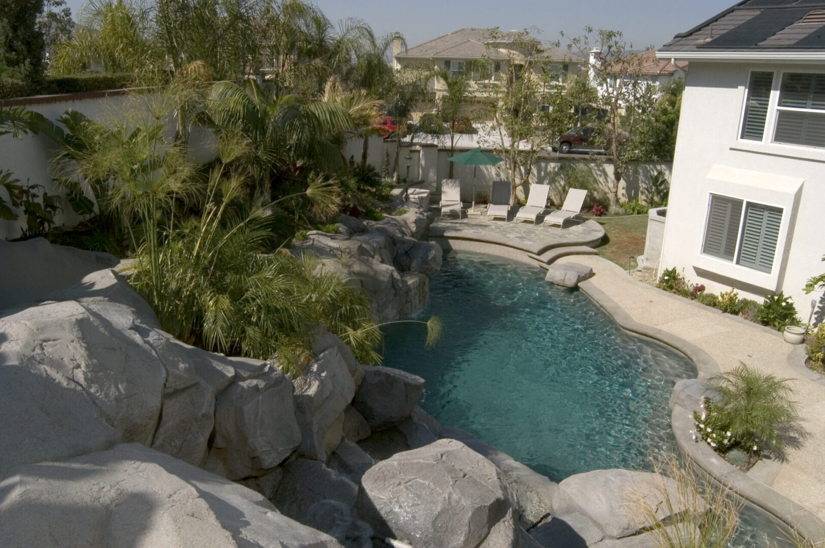 Pool with a wall of stones and a slide (aerial view)