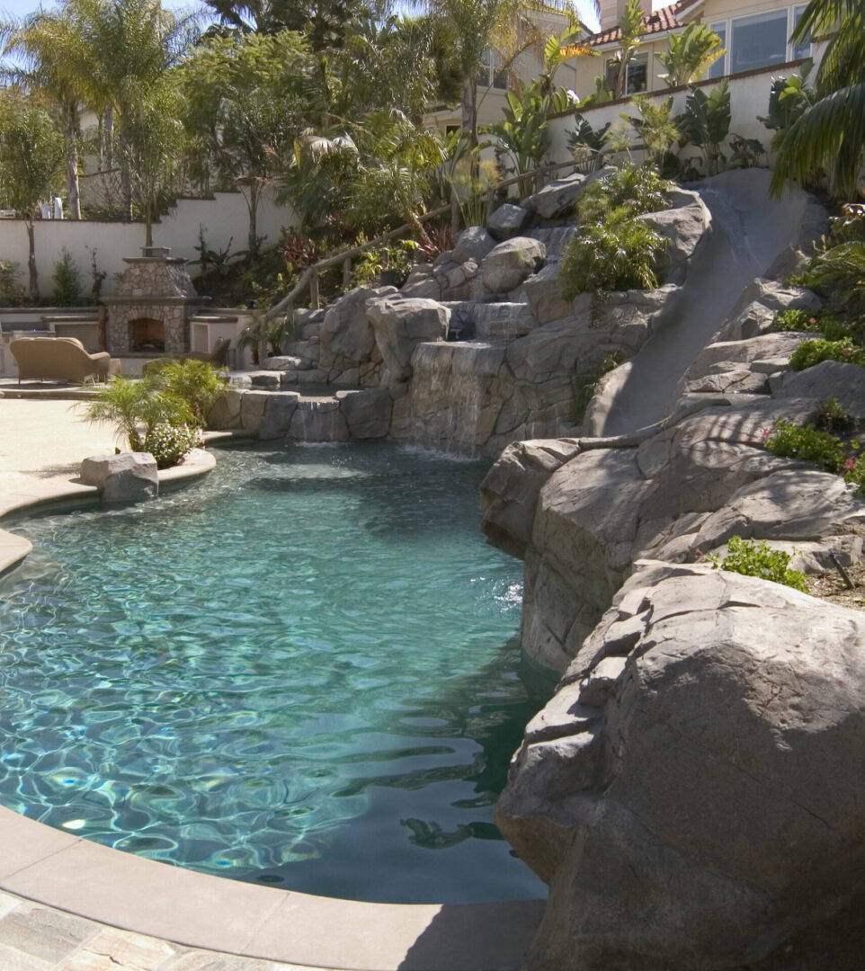 Pool with a wall of stones and a slide