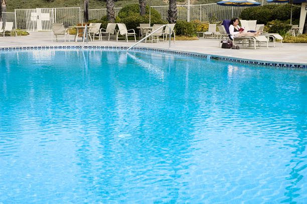 Pool Plastering ca "Woman relaxes at poolside, which conveniently offers copy space."