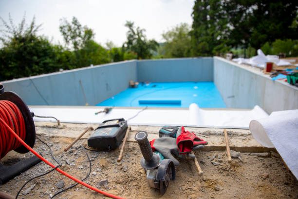 Construction site featuring a custom pool under development in Riverside, surrounded by tools and building materials.