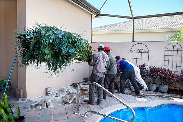 Three men are collaborating on pool maintenance at a residential property, ensuring the water is clean and clear during a pool remodeling in Eastvale, CA.