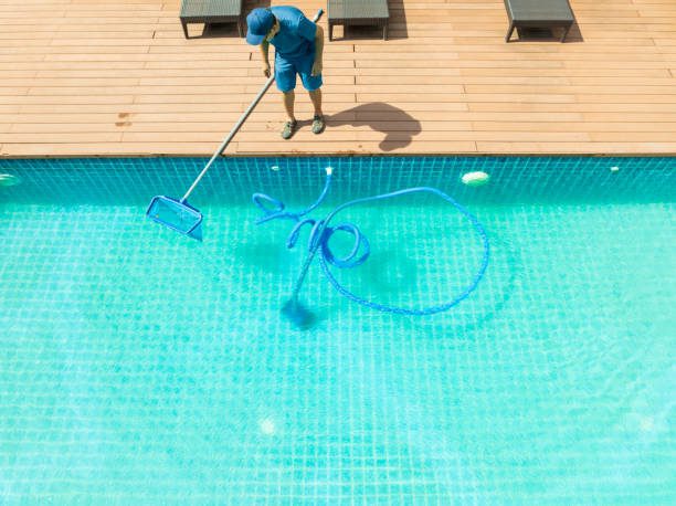 Pool remodeling in progress with a scoop net and automatic robot cleaner ensuring a clean and well-maintained swimming pool.